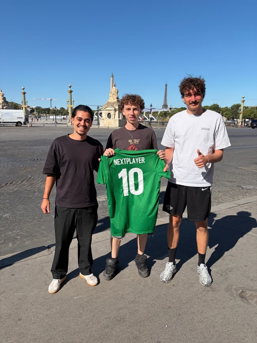 Trois jeunes hommes posent place de la Concorde à Paris, la tour Eiffel au fond ; celui du milieu tient un maillot vert Next Player floqué du numéro 10